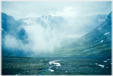 Clouds hanging in valley above town.