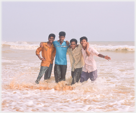 Four fully clothed students in the sea.