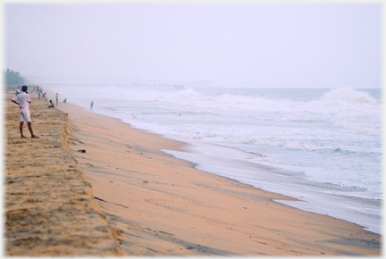 Sand at edge of sea with waves coming in.