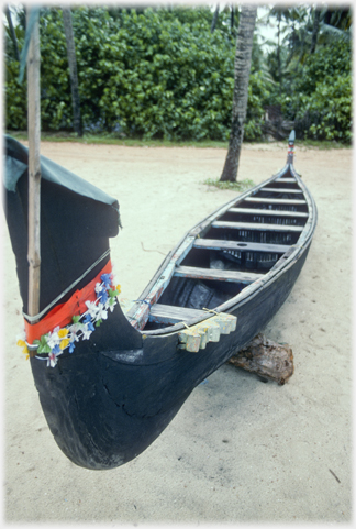 Black ceremonial boat with flowers.