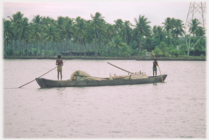Boat with two men punting.