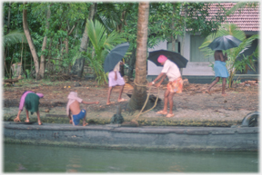 Family disembarking under umbrellas.