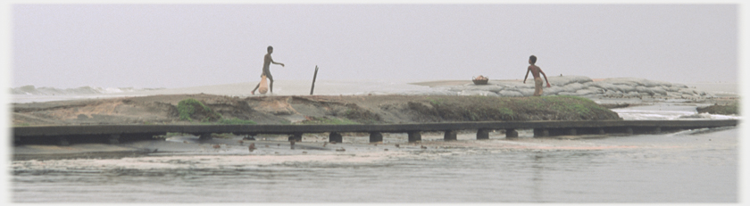 Two men in canoe, one standing.