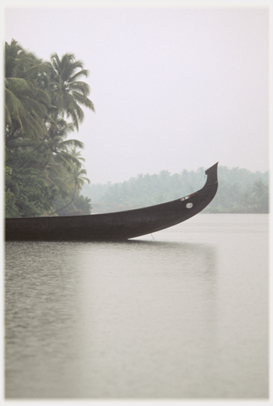 Prow of boat projecting into the river and the rain.