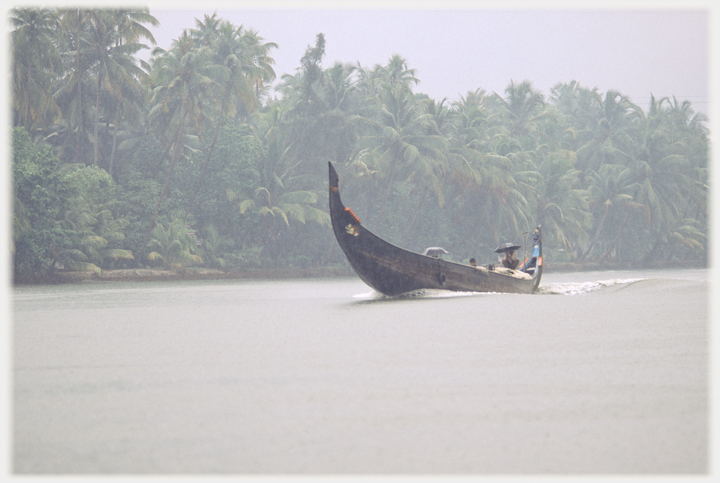 Long boat seeming to be going at speed causing a wave.