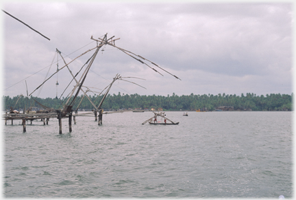 Canoe with men attending net frames.