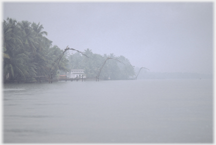 View along the lagoon's edge fading into the rain.