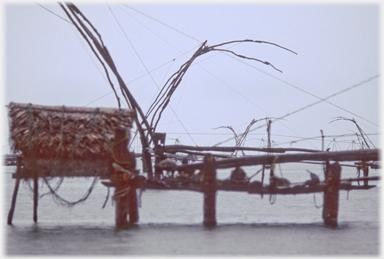 Hut on frame platform with palm thatch walls.