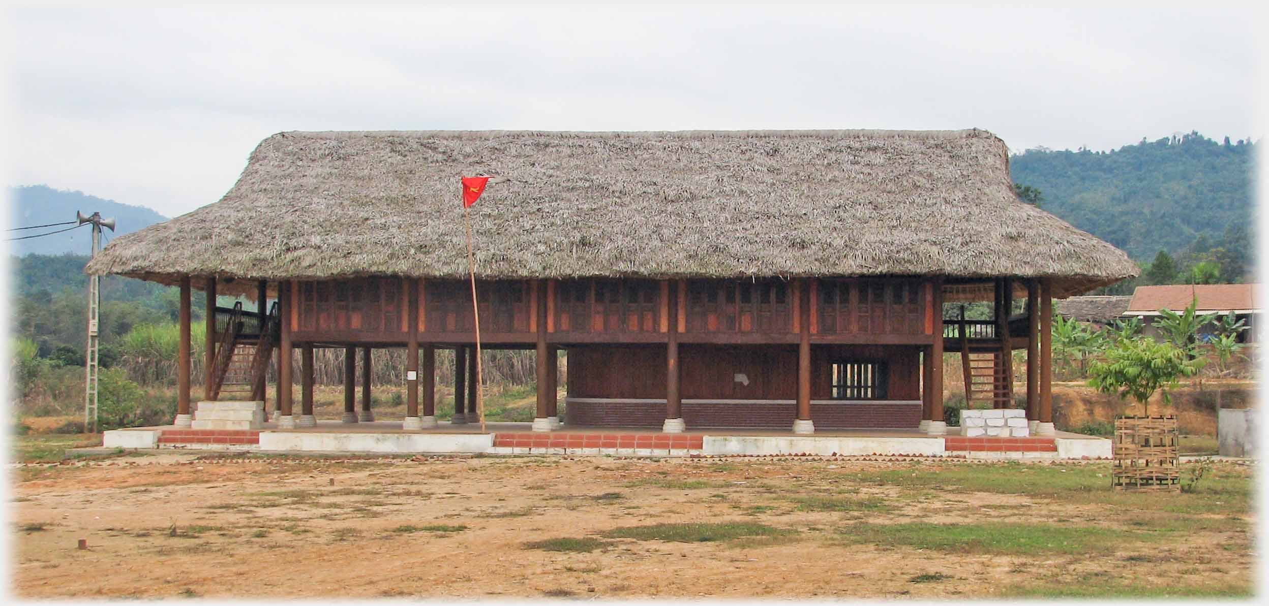 A well thatched stilt house  with national flag flying.
