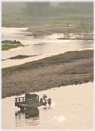 A tractor for carriage sitting in shallow water unattended.