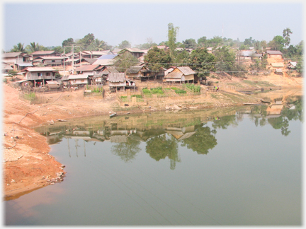 Houses ranged up on river bank.