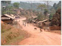Village street with dust road and people.