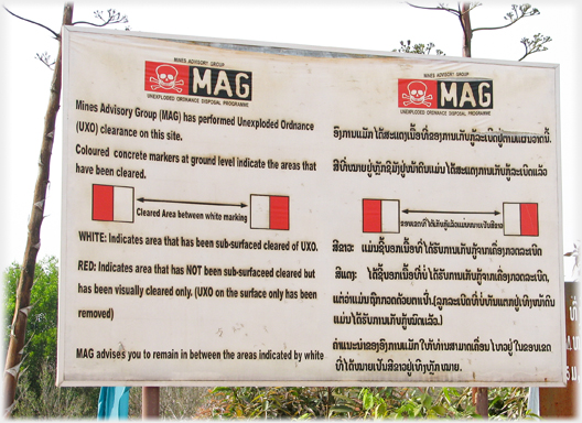 Sign showing markers designating paths cleared of bombs.