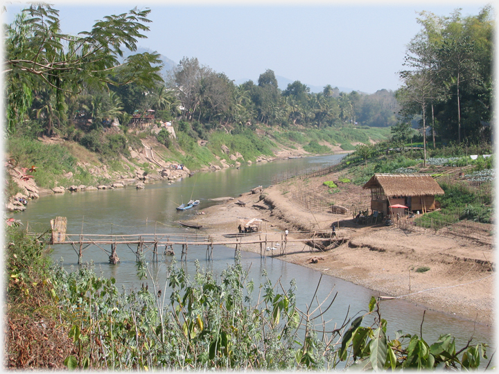 A foot toll bridge over the Nam Khan with keepers house.