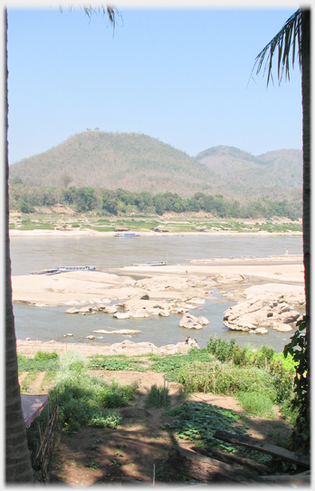 View across Mekong with moored boats on both sides.