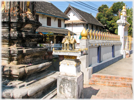 Model pagoda on pillar altar beside stupa.