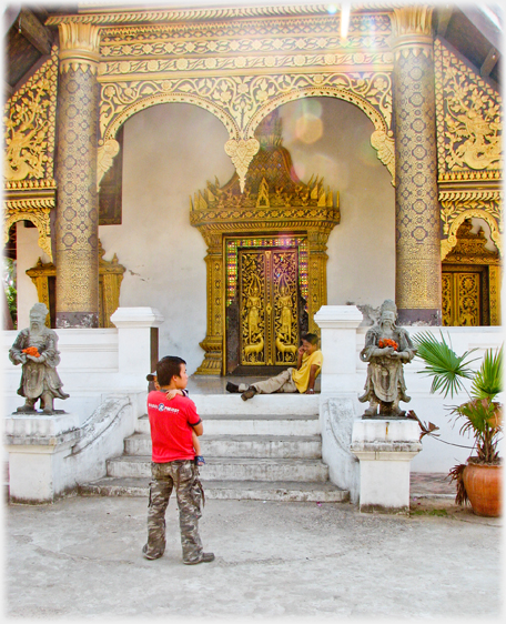 Entrance steps and portico with man holding child and man phoning.