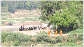 Three monks nearing the river bank.