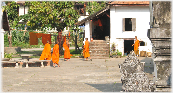 Five monks standing around a public area.