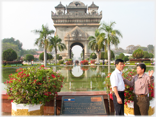 Two men talking beside the Patuxai Monument.