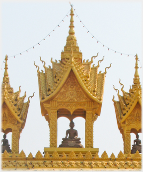 Three turrets with Buddhas in them on the gate to the Pha That Luang.