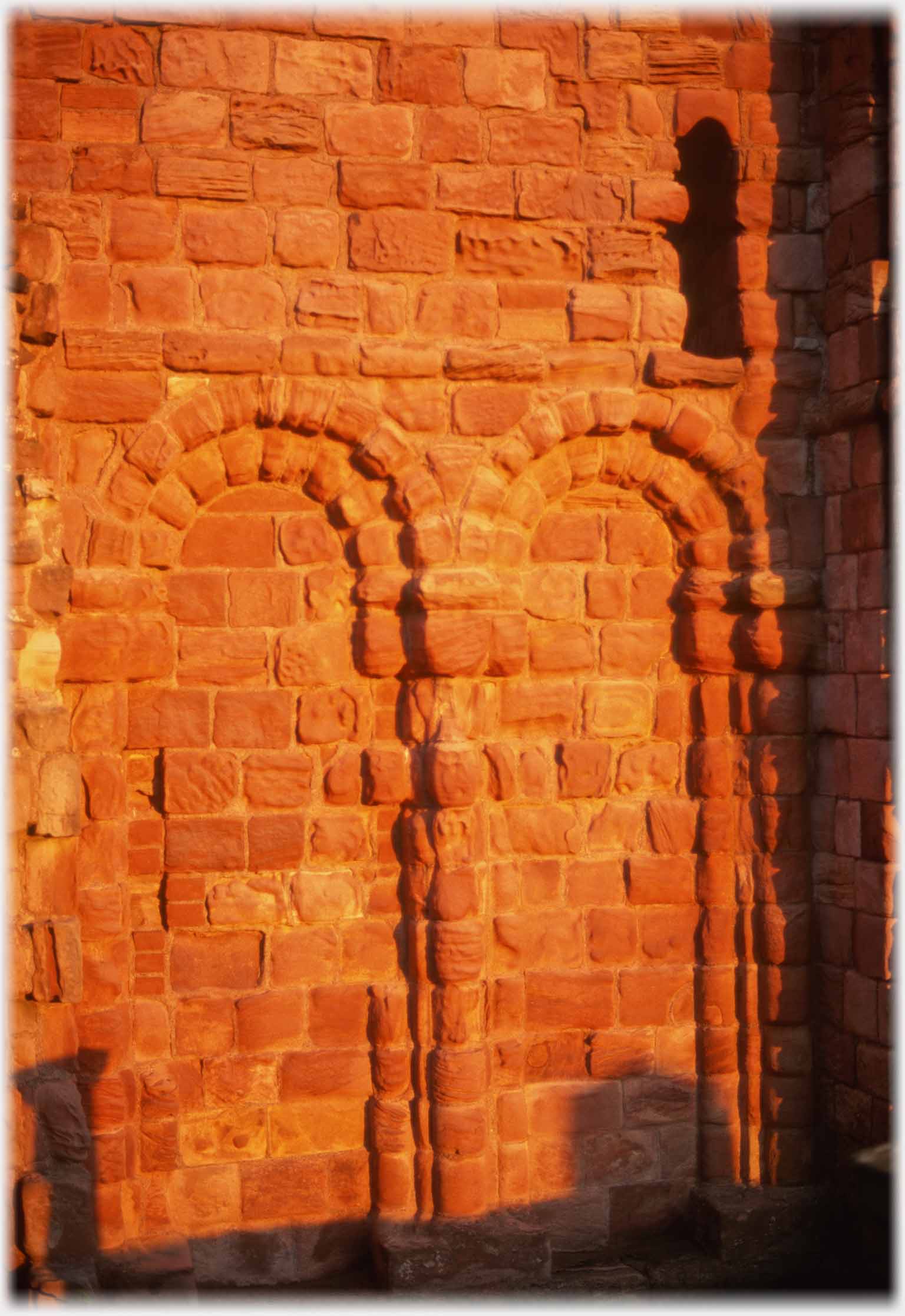 Two blank stone arches in warm sun light.