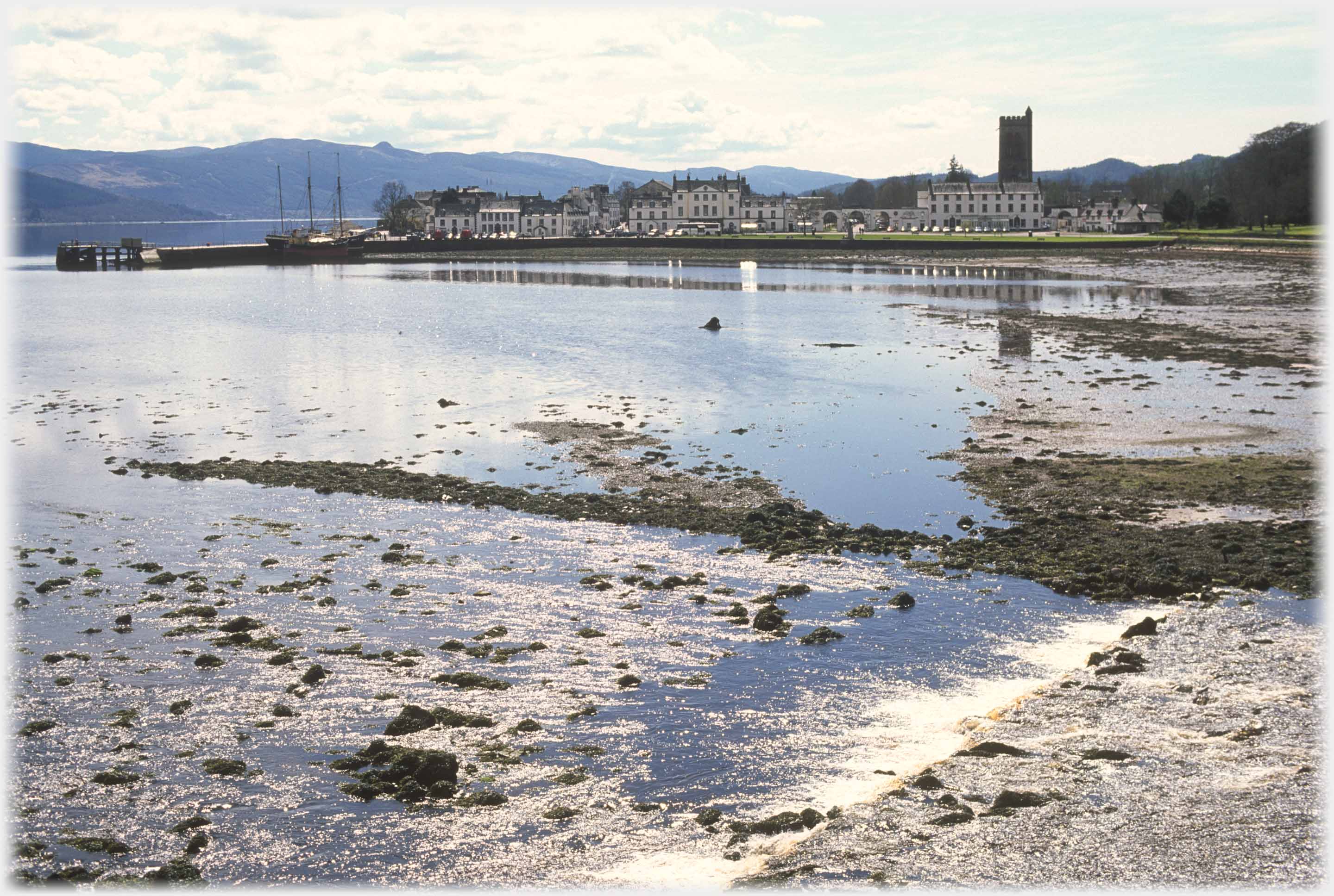 Low tide bay with village beyond.