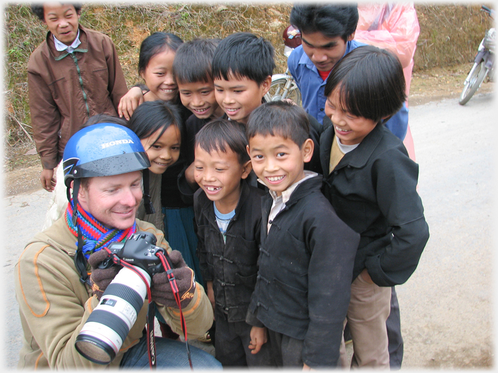 Westerner showing pictures to children.