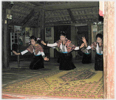 Three women kneeling and bowing arms outstretched.