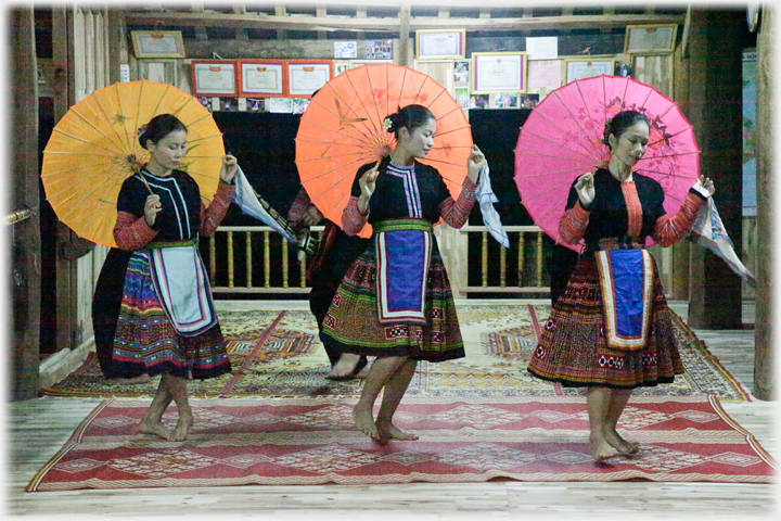 Three women with aprons and umbrellas.