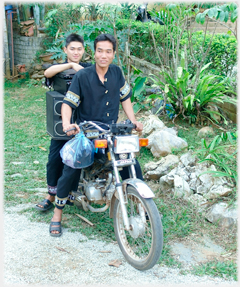 Two men on motorbike with large loudspeaker.