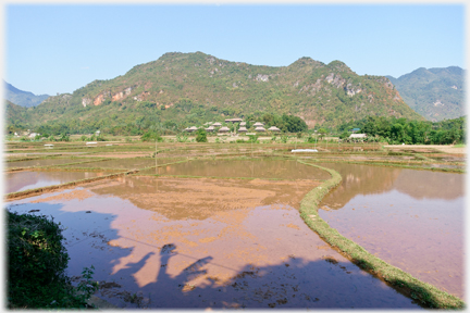 Flooded fields with village houses beyond.