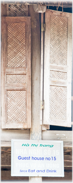 Textured shutters with sign below saying Guest house no 15/Serce Eat and Drink.