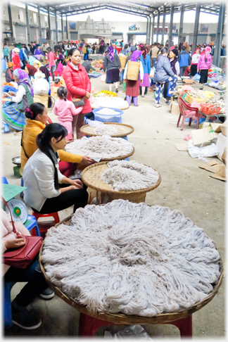 Vendors with flat baskets of noodles.