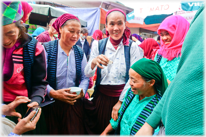 Women drinking in street together.