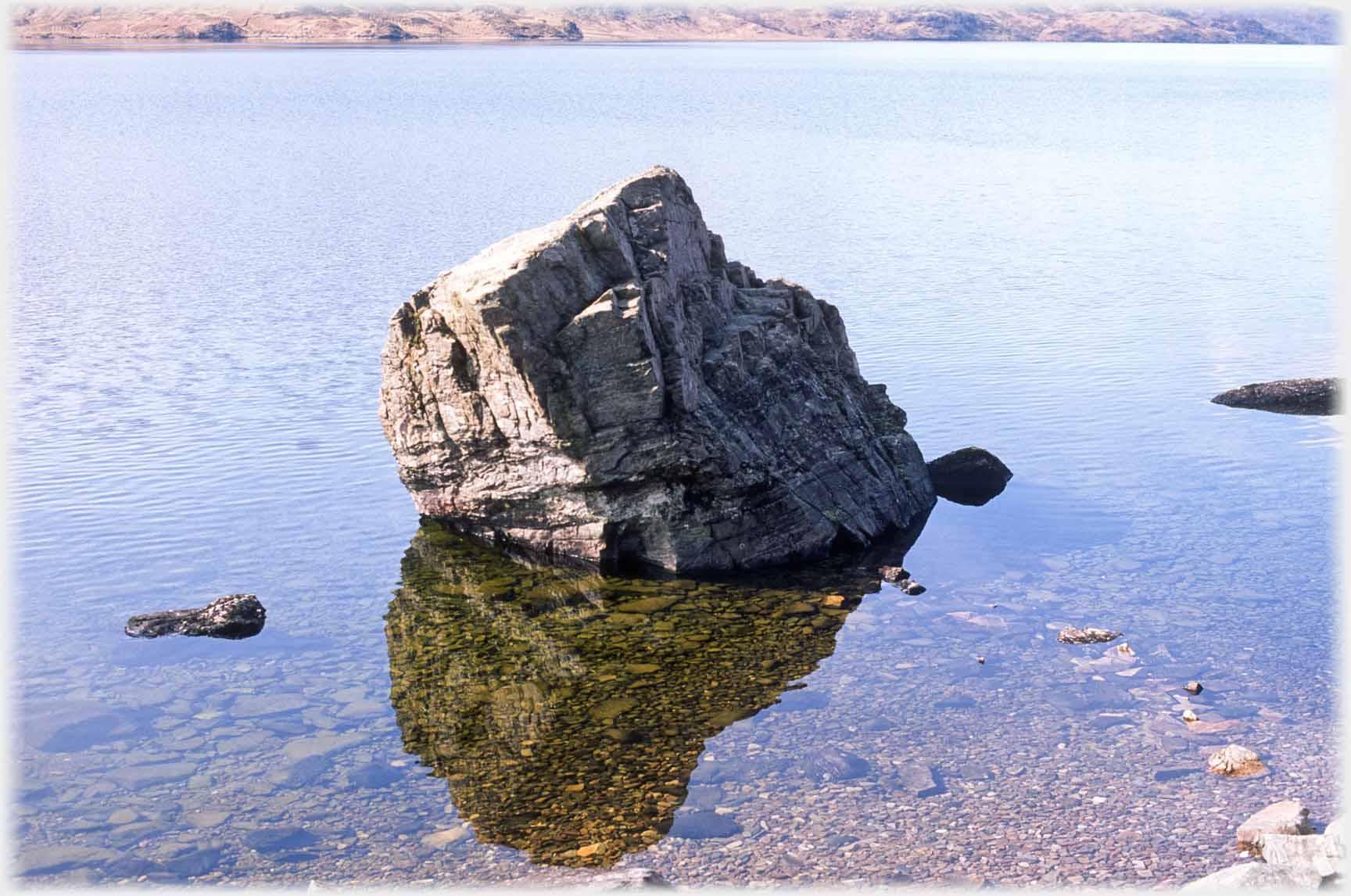 Rock and reflection in pelucid water.