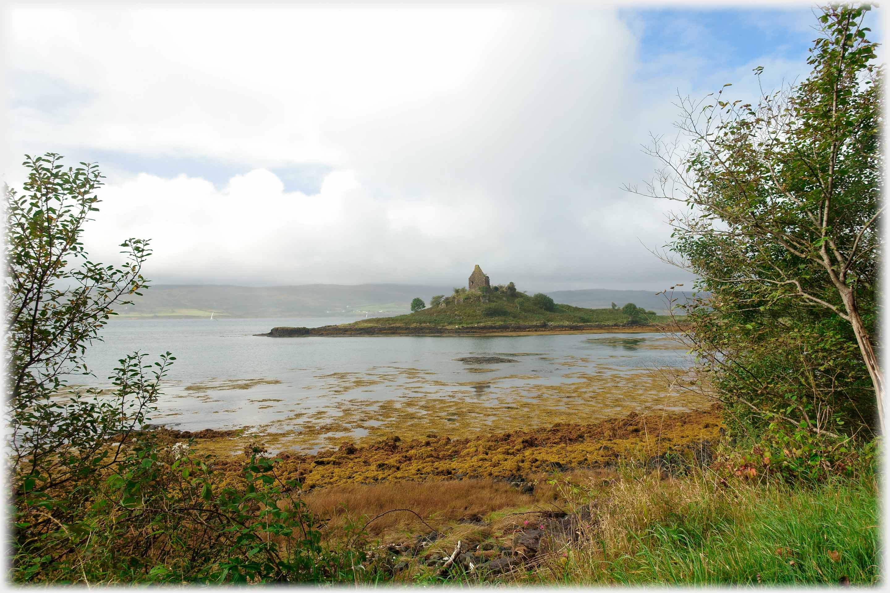 Gable end on promontory  with sea around.