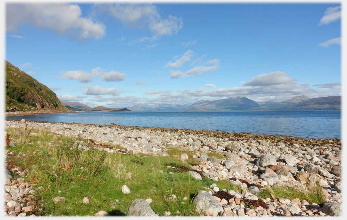 Pebble beach with hills and headland.