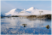 Frozen loch with white hills beyond.