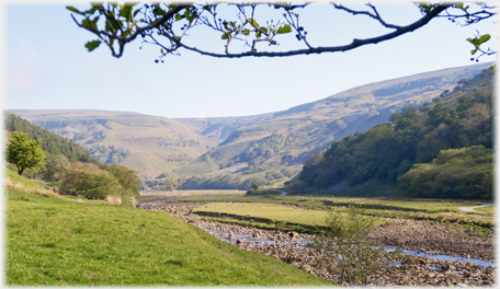 View up the valley with river in foreground.