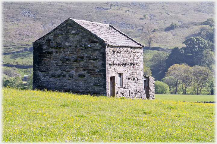 Barn with field in front of it.