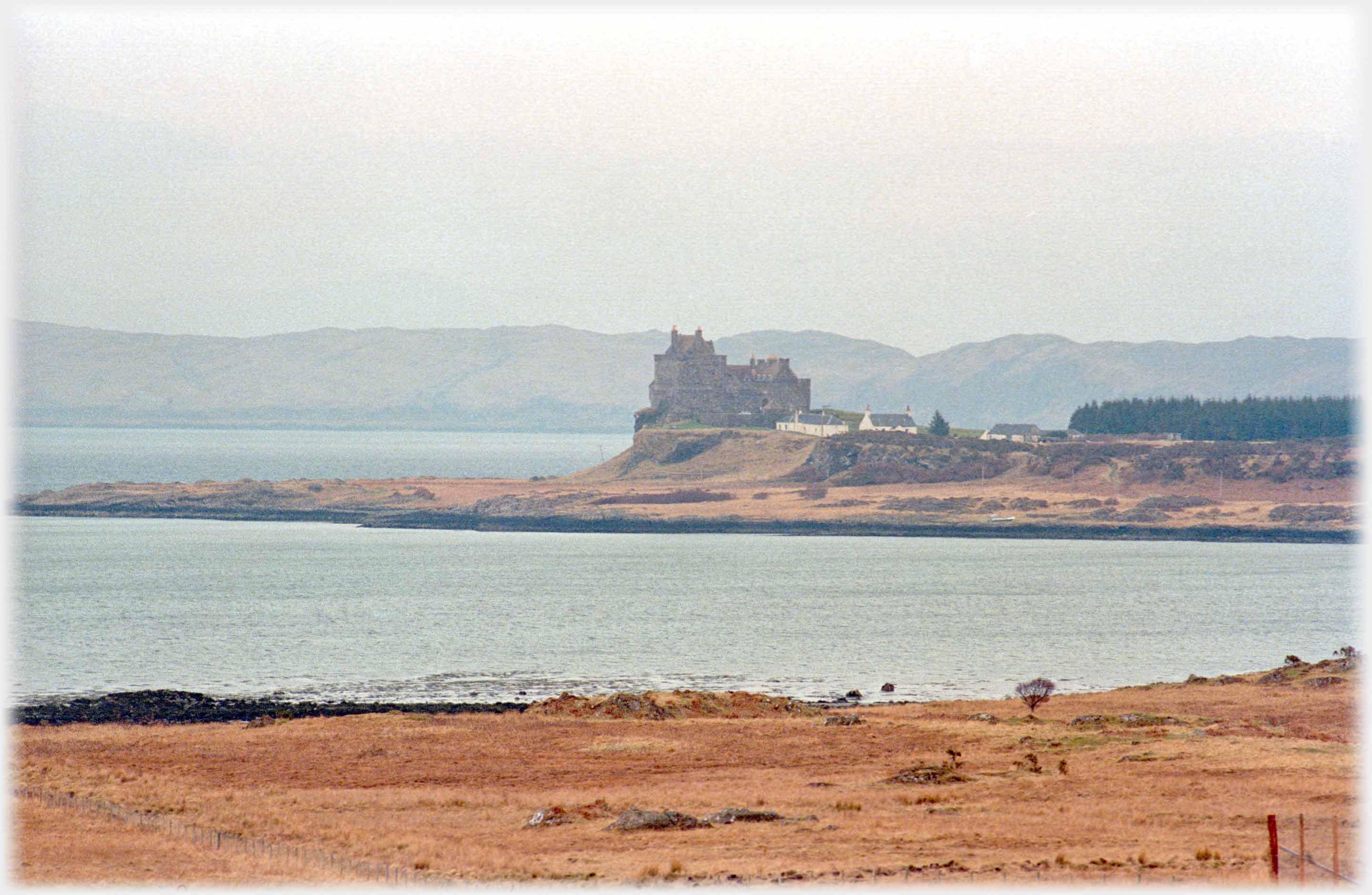 Castle on headland with houses beside it.