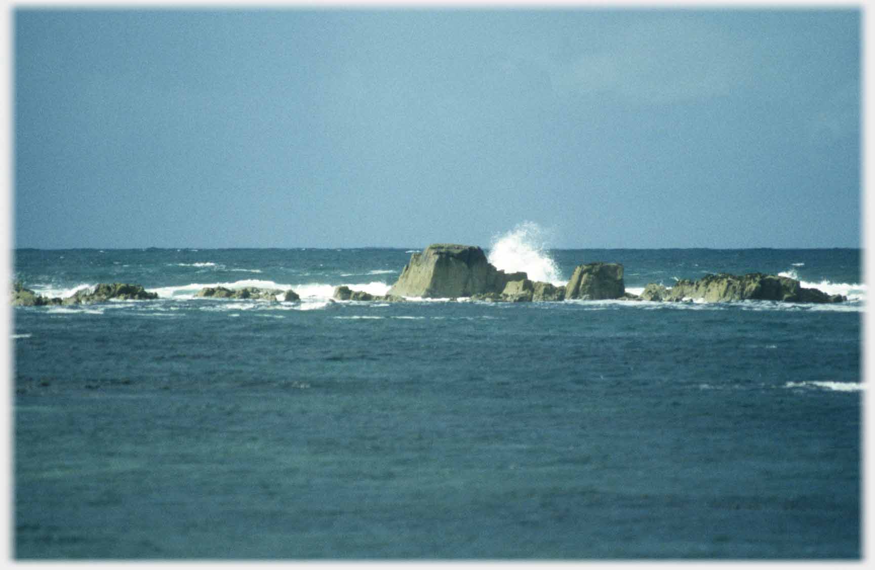 Line of rocks with waves breaking.