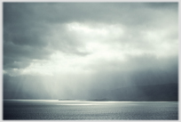 Shafts of light through clouds on the sea.