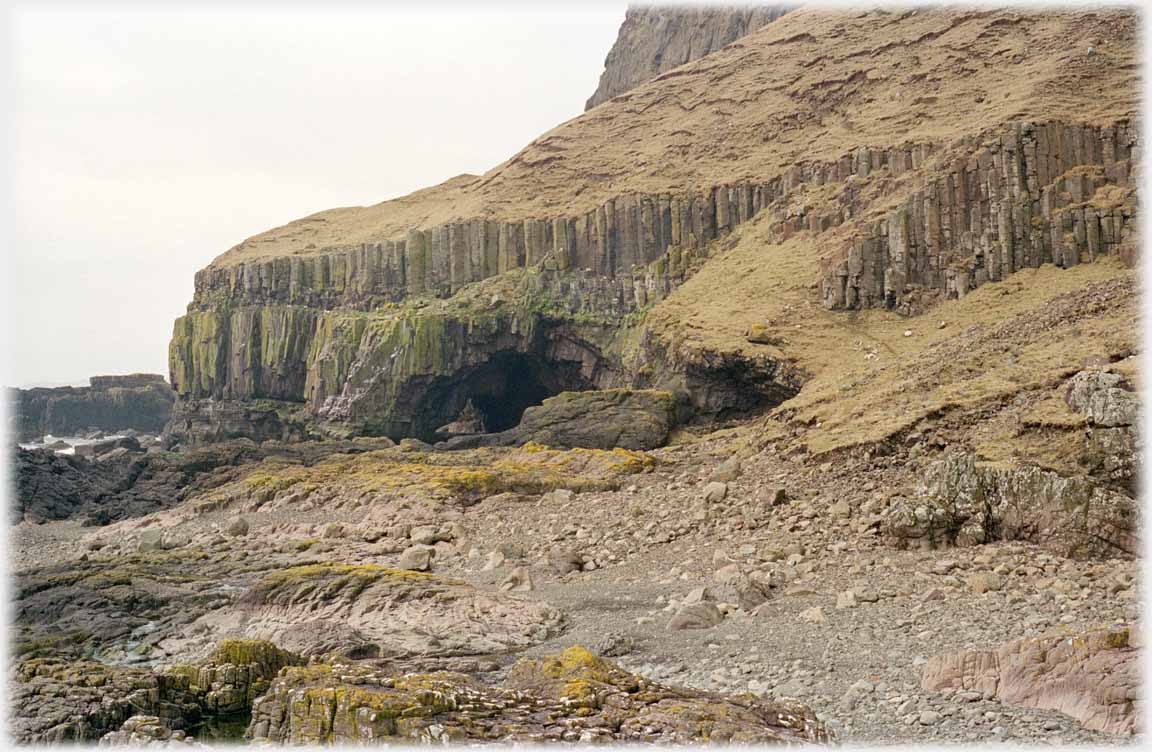 Basalt columns in cliff with cave.
