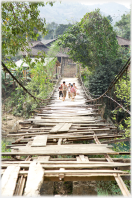 Children walking over broken bridge.