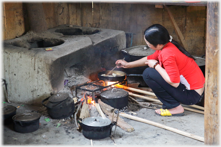 Woman cooking on open fire.