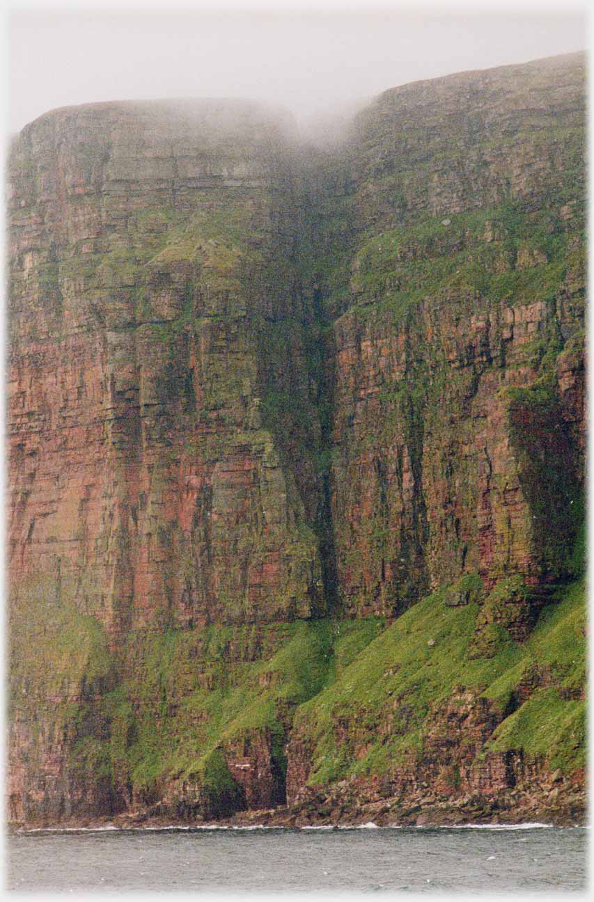 Shot of cliffs with clouds at top.