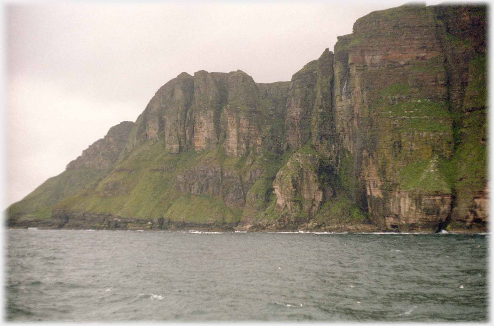 Cliffs rising from the sea at an angle.
