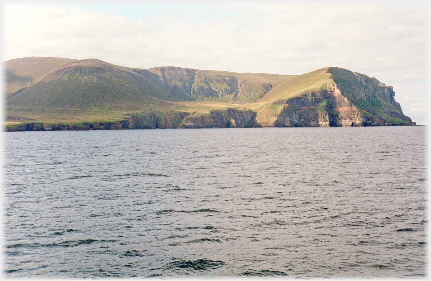 Semi-circle of hills cupping land above the sea.